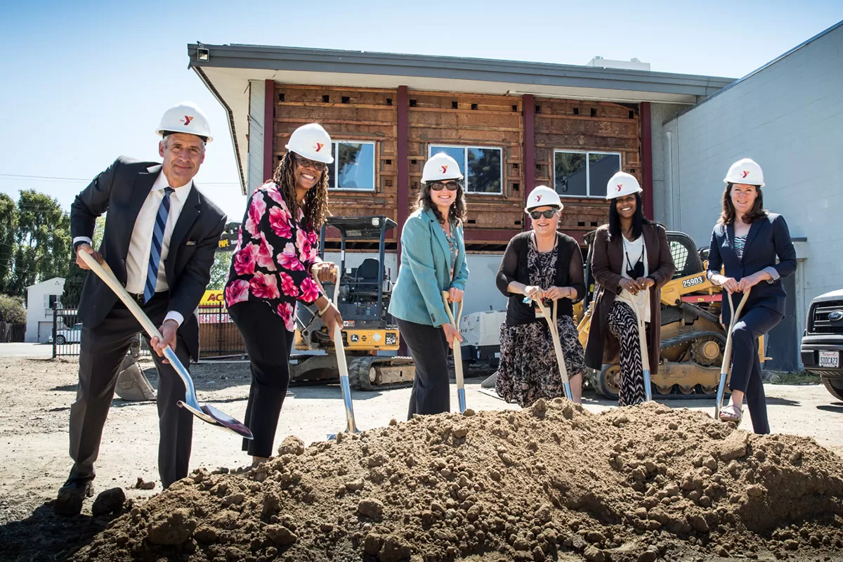 Group with hard hats and shovels breakign ground at new early learning center